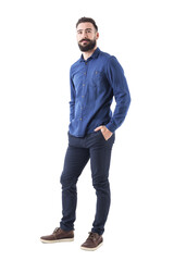 Cool smiling guy, with hands in pockets looking up wearing blue denim shirt and pants. Full body...