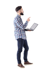 Young adult stylish business man with laptop pointing finger at presentation looks up. Full body isolated on transparent background.