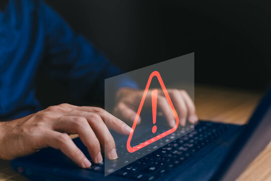 Businessman or it staffs, programmer, developer using computer laptop with triangle caution warning sign for notification error and maintenance concept. Hack system alert, warning computer system