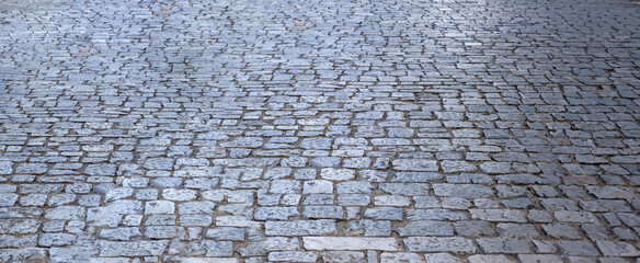 Stone paved footpath, cobblestone pathway background texture.