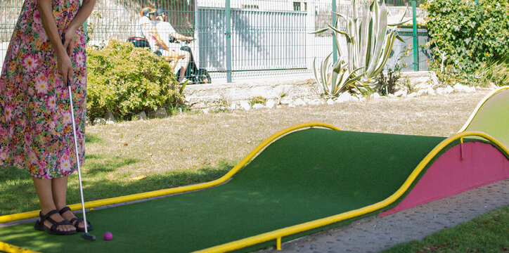 A woman playing minigolf on a grass