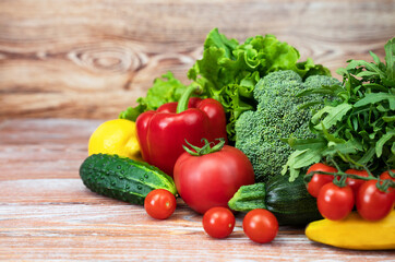 Fresh vegetables, fruits and greens on a wooden background. Healthy food, harvesting, farming. Copy space.
