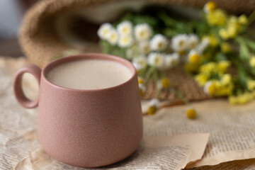Cup of cappuccino with milk or cacao and wildflowers