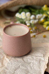 Cup of cappuccino with milk or cacao and wildflowers