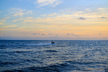 Naklejka premium ride a jet ski on the beach, sunset over the sea, sunset in the sea, sea and sky, sunset over sea, beautiful sunset sky, blue and orange sky, sunset wallpaper