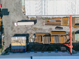 Truck preparing for loading stack of metal pipes with gantry crane