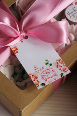 Homemade marshmallows in a paper gift box. Zephyr flowers. The box is tied with a ribbon tied into...