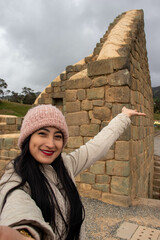 Mujer joven turista haciendose una foto en las ruinas de ingapirca en la provincia del cañar, selfie en las ruinas arqueologicas 