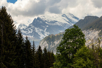 Swiss Alps in Switzerland in the Summer With Mountains Peaking Through the Clouds in the Background