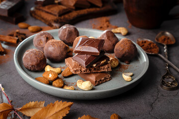 Pieces of chocolate and nuts in a plate on a dark background