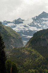 Swiss Alps in Switzerland in the Summer with Mountains Peaking Through Clouds in the Background