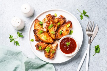 Grilled meat. Chicken wings in bbq sauce.. Top view on white stone table.