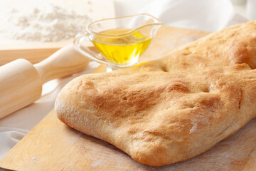 Delicious homemade Italian ciabatta bread with olive oil on a rustic wood.