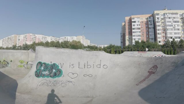 bike ride through a concrete skate park painted by street hooligans on a sunny summer hot day morning