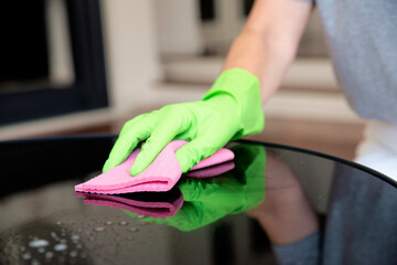 Close-up of a woman's hand wiping the dining table at home