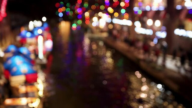 Blurred background of San Antonio river walk at night with Christmas lights
