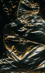 Grunge texture. Old film. Abstract background. Wrinkled black paper with yellow blue neon ornament pattern on dark light shadow.