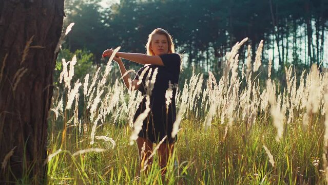 Attractive athletic girl warms up after running in a wheat field, athlete sport recreation post-workout recovery