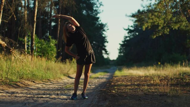 Girl limbering-up and stretching arms before sport running jog workout