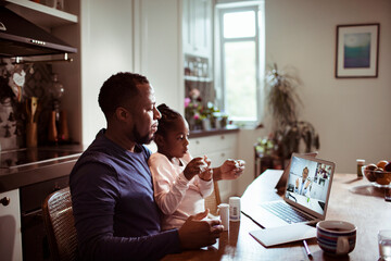 Worried single father talking to the doctor over a video call about his sick daughter