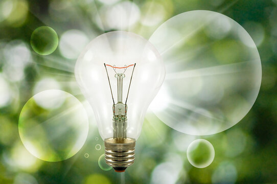  light bulb on a blurred green background and transparent abstract balls