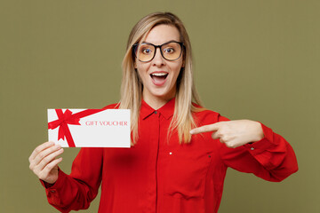 Young happy fun woman she wear red shirt casual clothes glasses hold point finger on gift...