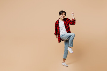 Full body young fun man of Asian ethnicity he wear red shirt casual clothes doing winner gesture...
