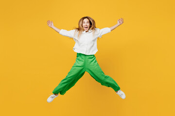 Full body young ovrjoyed excited caucasian happy woman she wears white shirt casual clothes jump high with outstretched ars hands isolated on plain yellow background studio portrait Lifestyle concept