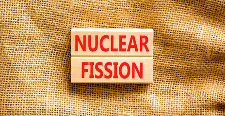 Nuclear fission symbol. Concept words Nuclear fission on beautiful wooden blocks. Beautiful canvas...