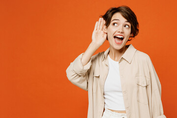 Young curious nosy smiling happy caucasian woman wear beige shirt casual clothes try to hear you...