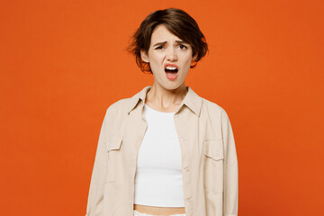 Young sad dissatisfied disappointed mad caucasian woman she wears beige shirt casual clothes look...