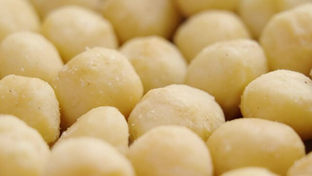 Shelled macadamia nuts close up. Nutritious diet food. Rotation. Macro