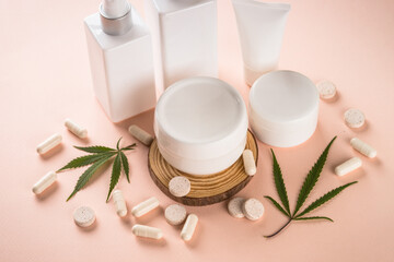 Obraz na płótnie Canvas Cannabis cosmetic products. Natural cosmetic. Cream, soap, serum and others with hemp leaf. Flat lay image on pink background.