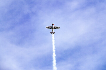 Yak plane in the blue sky engaged in acrobatic tricks.
