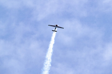 Yak plane in the blue sky engaged in acrobatic tricks.
