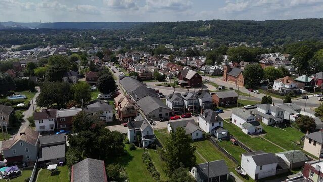A wide forward aerial establishing shot view of a typical Pennsylvania small town in summertime. Pittsburgh suburbs.  	