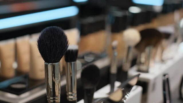 Various makeup brushes in a beauty salon or cosmetics store, close-up