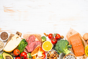 Healthy food products at white. Balanced nutrition. Salmon fish, beef, cheese, beans, nuts and...