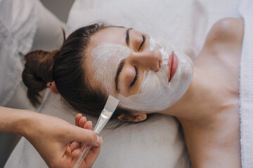 Young woman receiving nourishing face mask with particles atr spa salon. Beautiful woman face skin care. Facial treatment. Cosmetic procedure. Healthy lifestyle