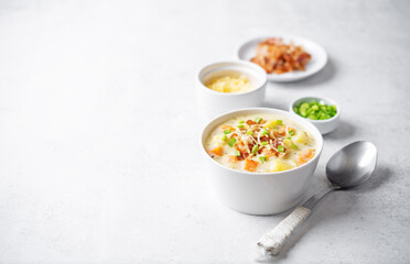 Fresh hot chowder soup with fried bacon slices and shredded cheese in a bowl