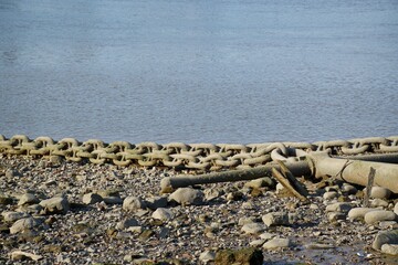 Disused anchor and chain on the stony beach 