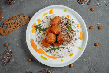 Potato croquettes - mashed potatoes balls breaded and deep fried, served with different sauce.