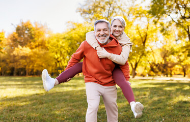 Portrait of lovely happy elderly couple on morning run outside in city park.