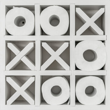 White tic-tac-toe themed toilet paper holder mounted on the bathroom wall