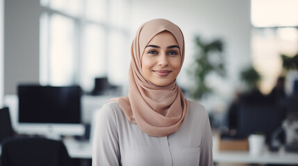 A Muslim Woman wearing a headscarf at work, smiling