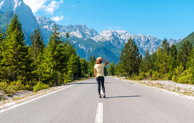 A tourist in summer walking on the road in the Valbona valley enjoying the freedom, Theth national park, Albanian Alps, Valbona Albania
