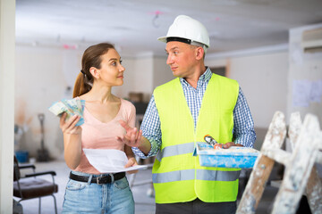Man builder receiving money from woman employer, construction manager.