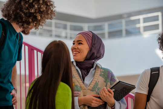 A Group Of Happy Diverse College Students Are Walking In The University Hallway Focus On A Muslim Girl In Hijab.