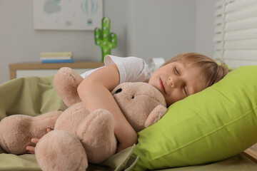 Little boy snoring while sleeping with teddy bear in bed at home