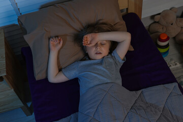 Little boy snoring while sleeping in bed at night, above view
